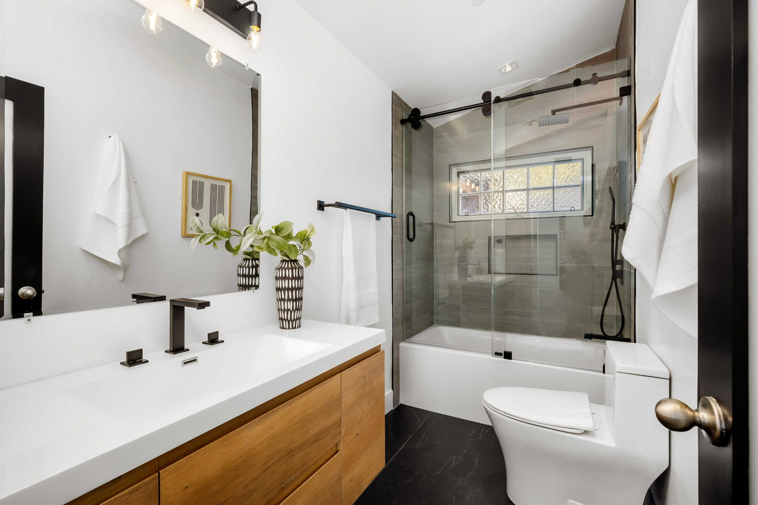 New bathtub with contemporary fixtures, a window, and built-in storage