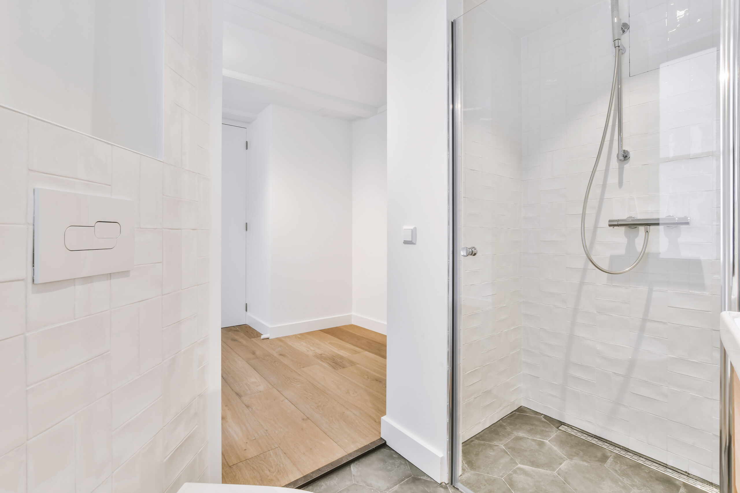 This image features a beautiful rectangular bathtub with a surrounding ledge. There is a grab bar on the wall along with a mirror the homeowner put up. 