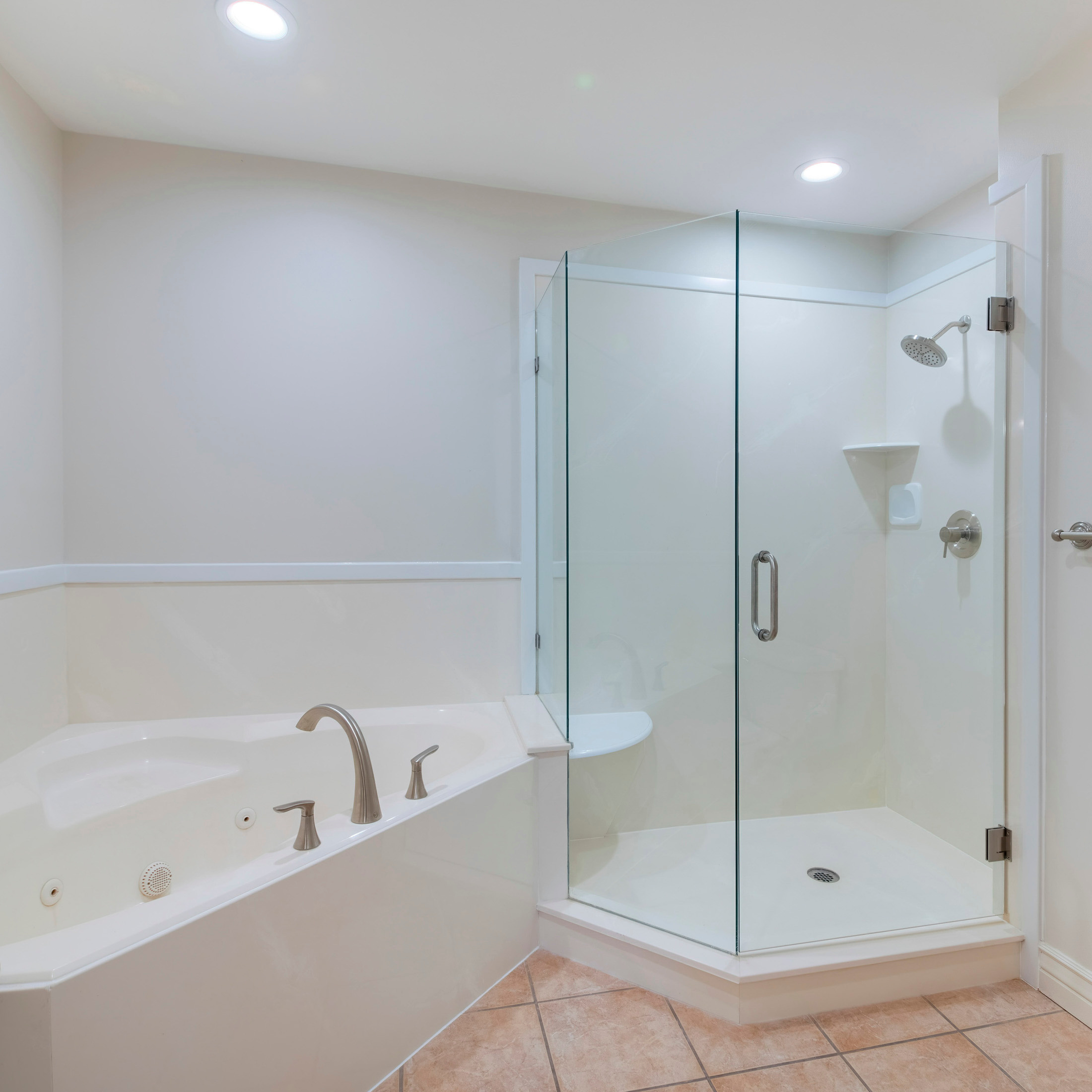 Garden tub with shower in glass stall, tile flooring
