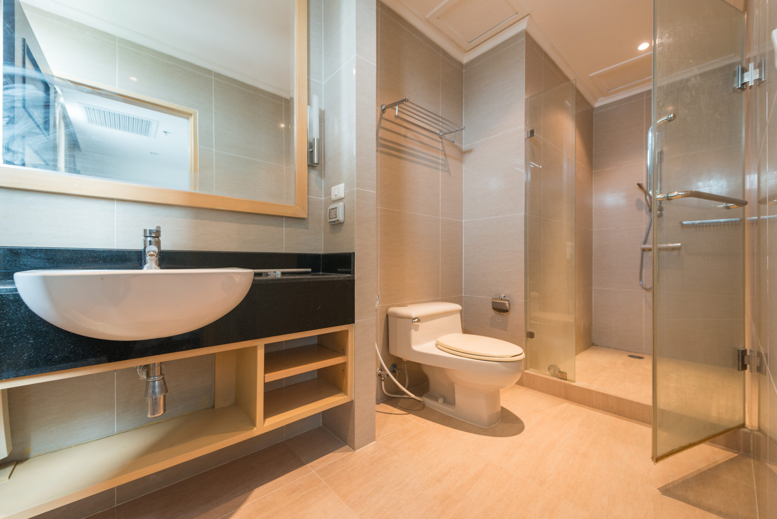 Warm bathroom with a large vanity and a new walk-in shower