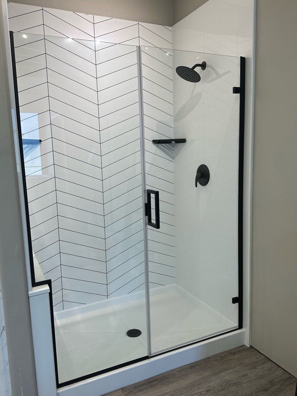 New walk-in shower with gray walls, a glass sliding door, and silver rails