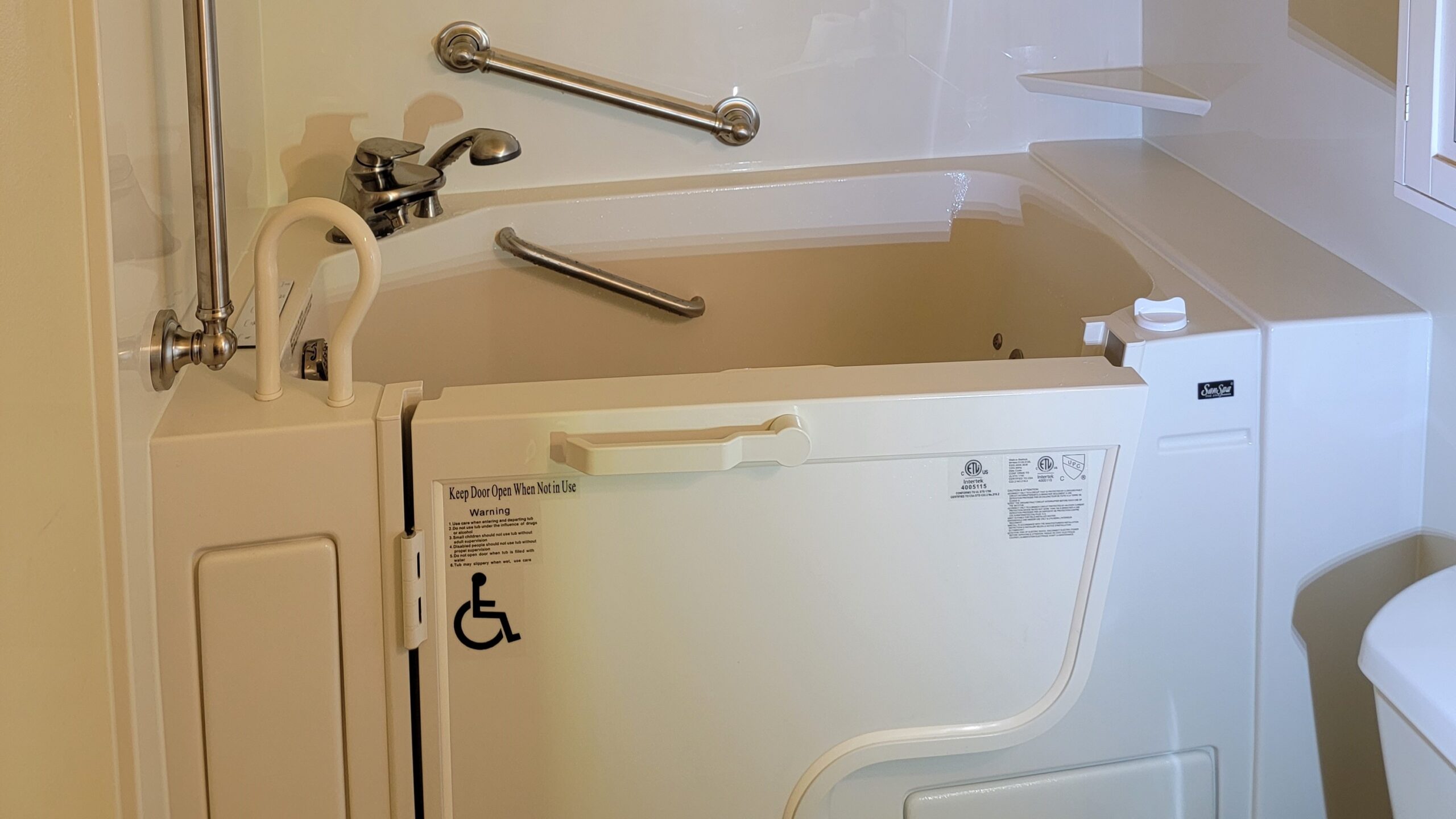 Small home bathroom with newly installed white walk-in bathtub