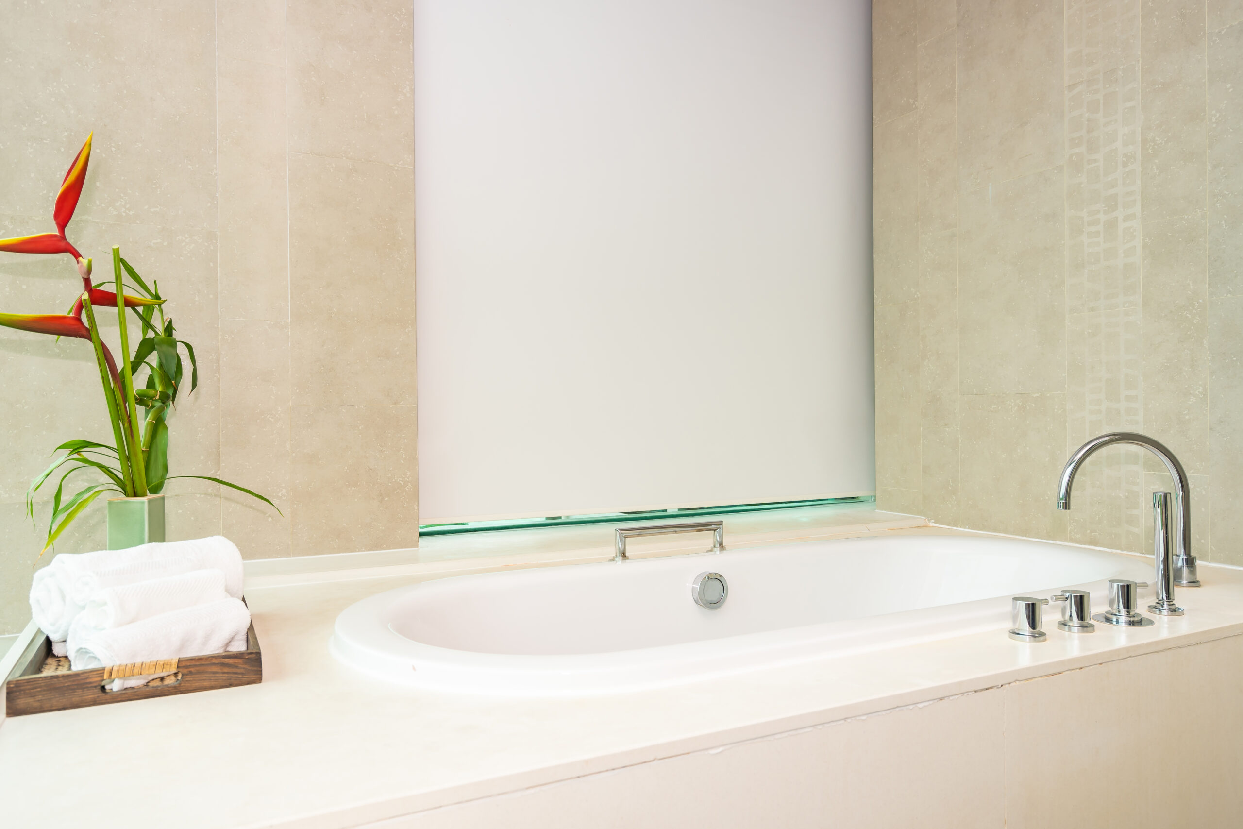 A lovely bathtub in a bathroom with a chic beige color scheme.