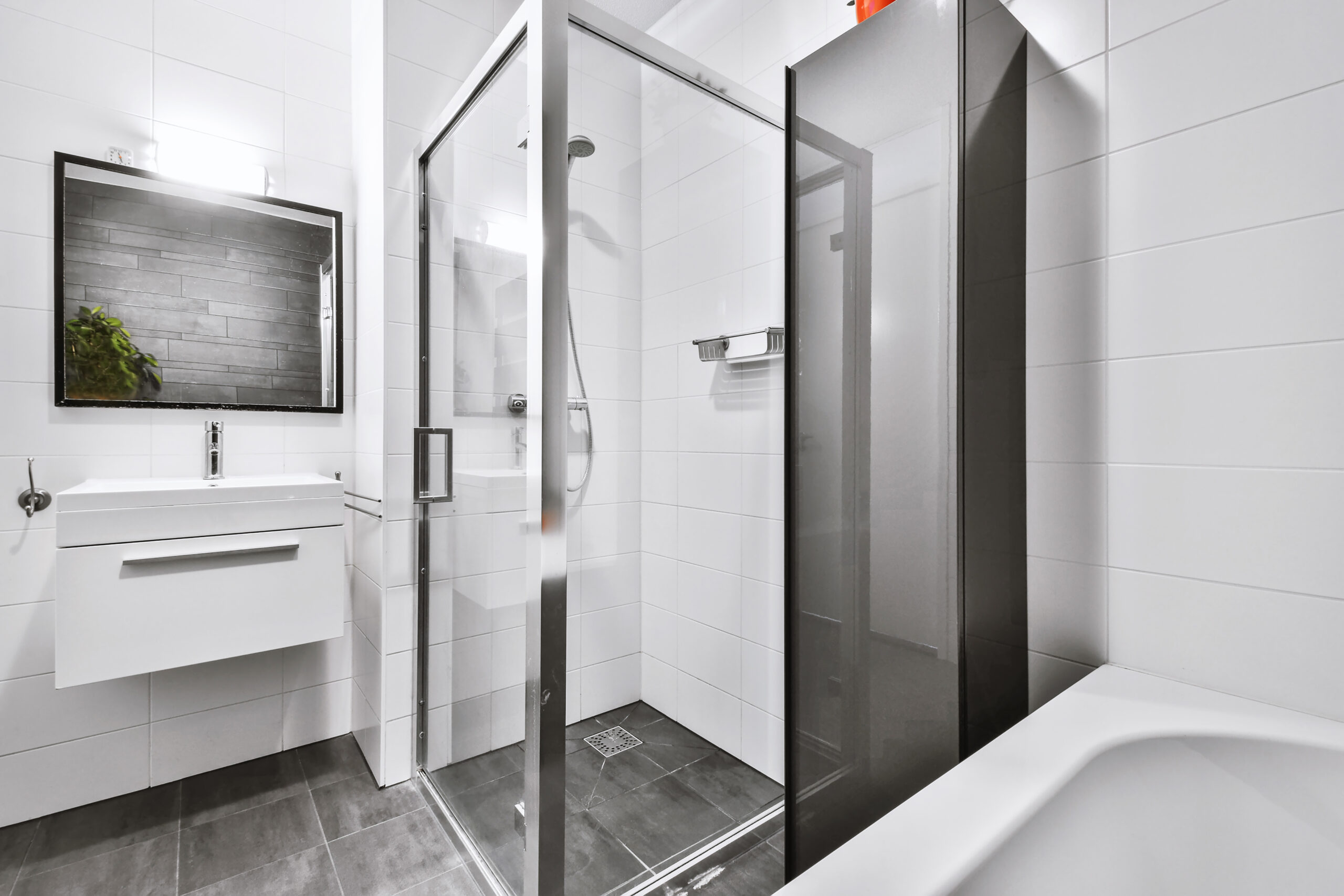 This image features a beautiful bathtub, walk-in shower, and sink against the wall.