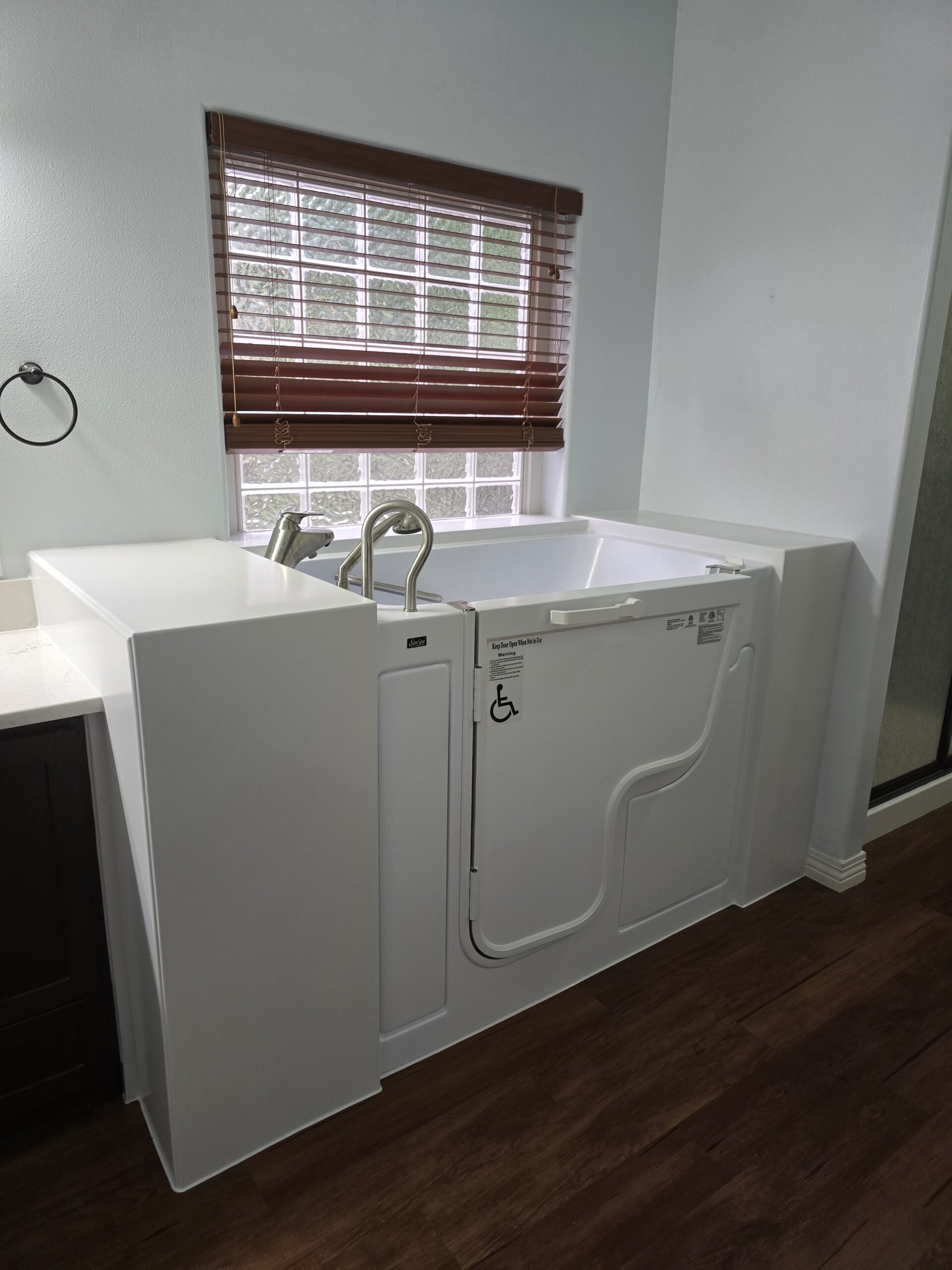 This is a cozy walk-in tub with warm tile surroundings and soft lighting.