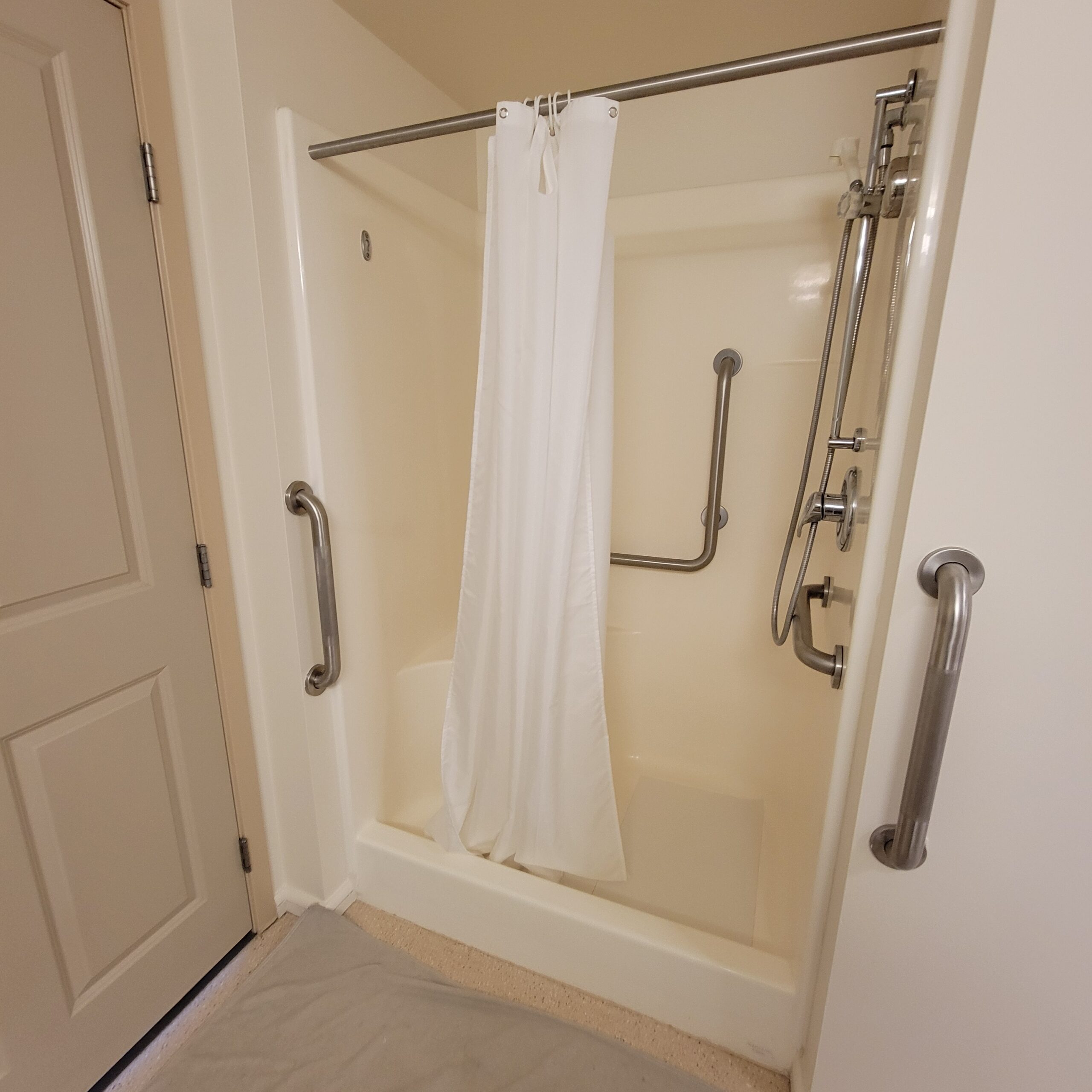 Tub-to-shower conversion with built-in seating and white shower curtain in a Tacoma, WA bathroom